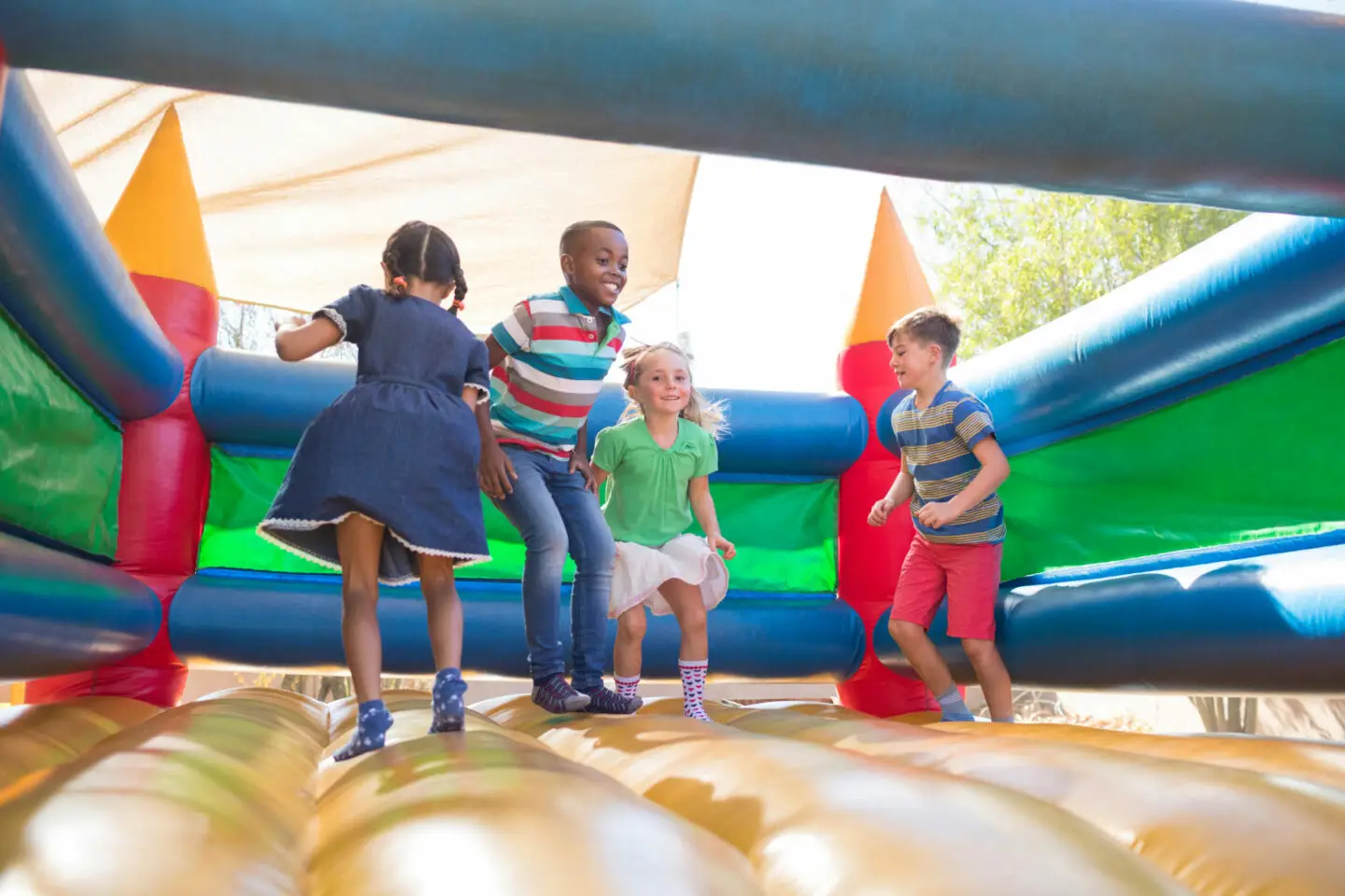 Friends playing on bouncy castle at playground